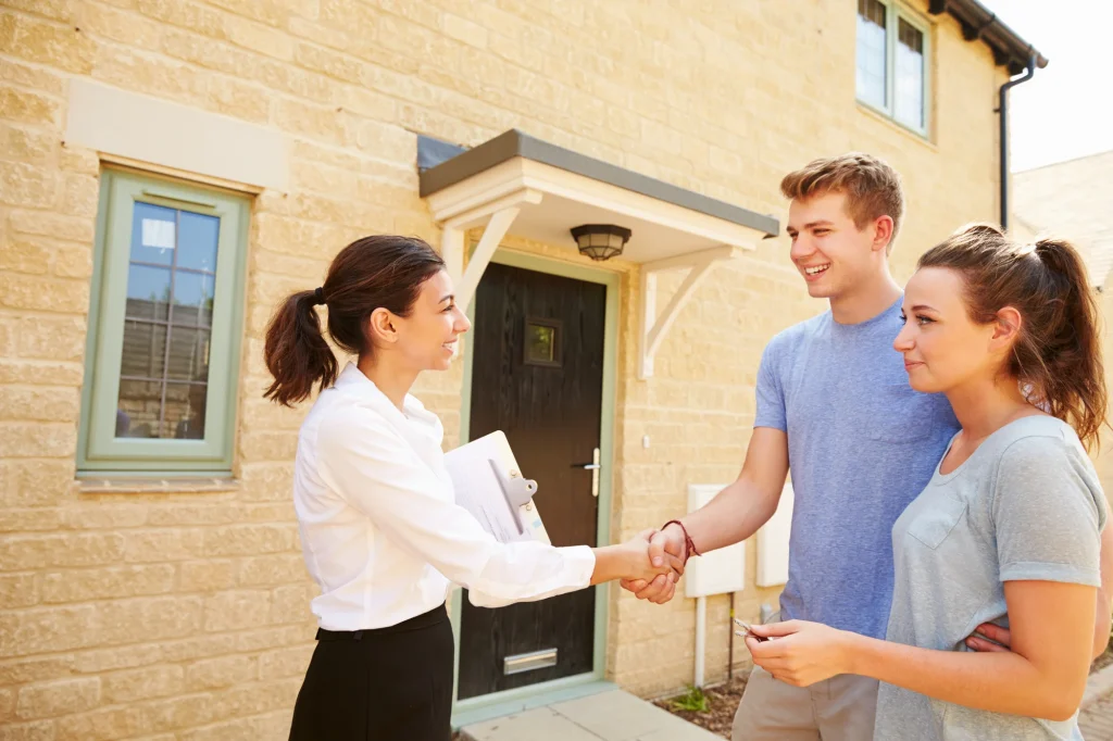 Real estate agent shaking hands with owners